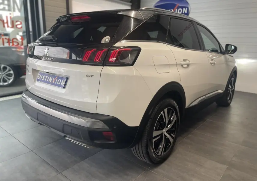 Vue 3/4 arrière droite du Peugeot 3008 GT blanc nacré avec toit noir et jantes alliage bi-ton.