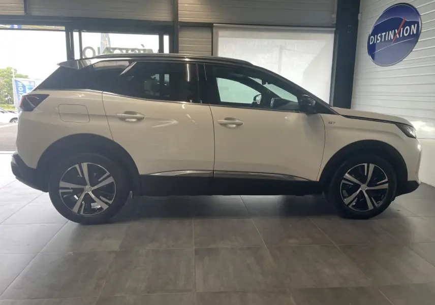 Peugeot 3008 GT blanc nacré en profil droit, toit noir, jantes alliage bi-ton et détails chromés visibles.
