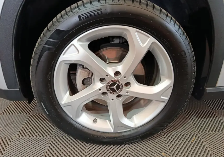 Gros plan sur la roue avant droite d'une Mercedes GLA 200 d gris clair avec jante alliage cinq branches et pneu Pirelli.