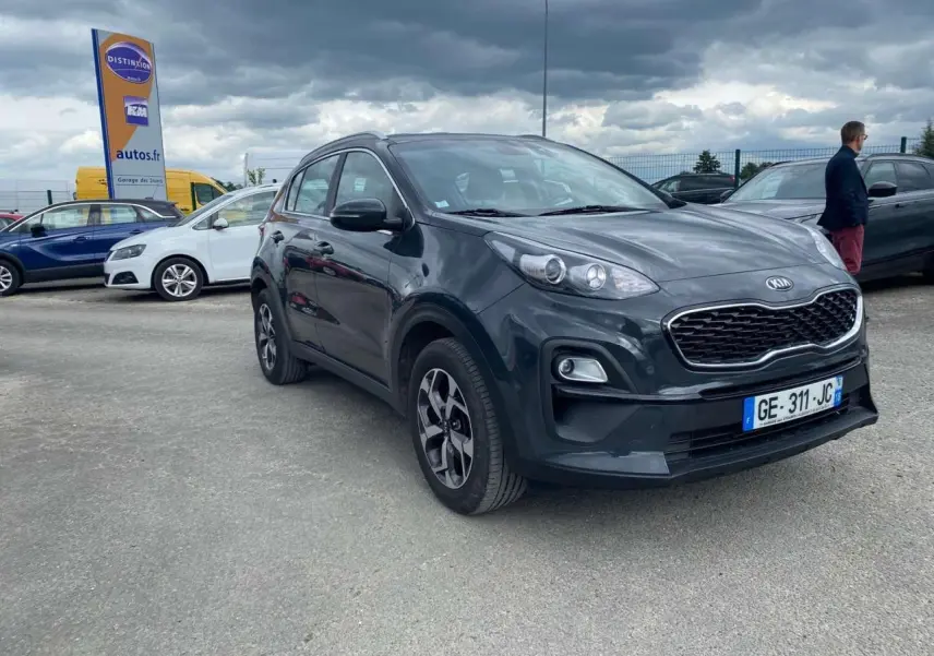 KIA Sportage gris foncé en 3/4 avant droit, avec jantes alliage noires et calandre distinctive Black Edition.