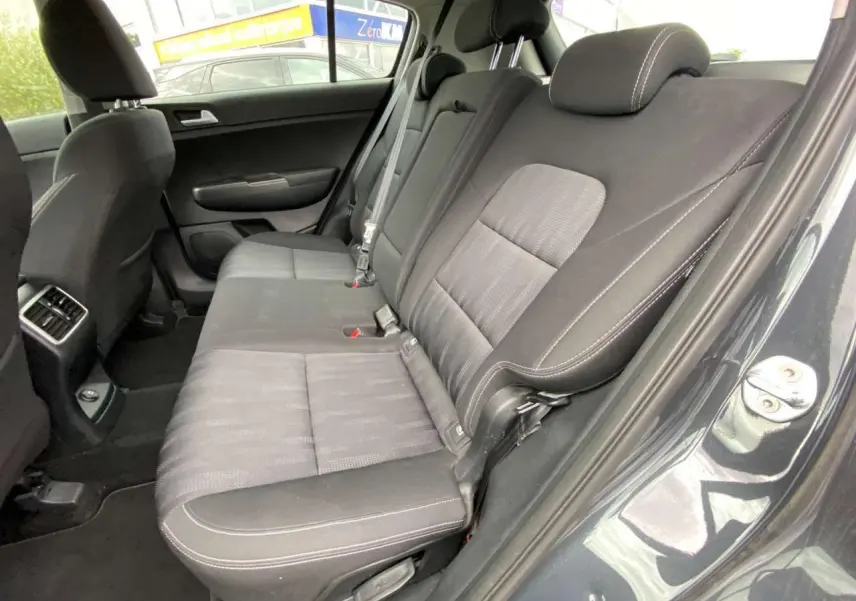 Vue intérieure côté droit de la banquette arrière grise foncée du KIA SPORTAGE 2021 Black Edition avec sellerie tissu et surpiqûres blanches.
