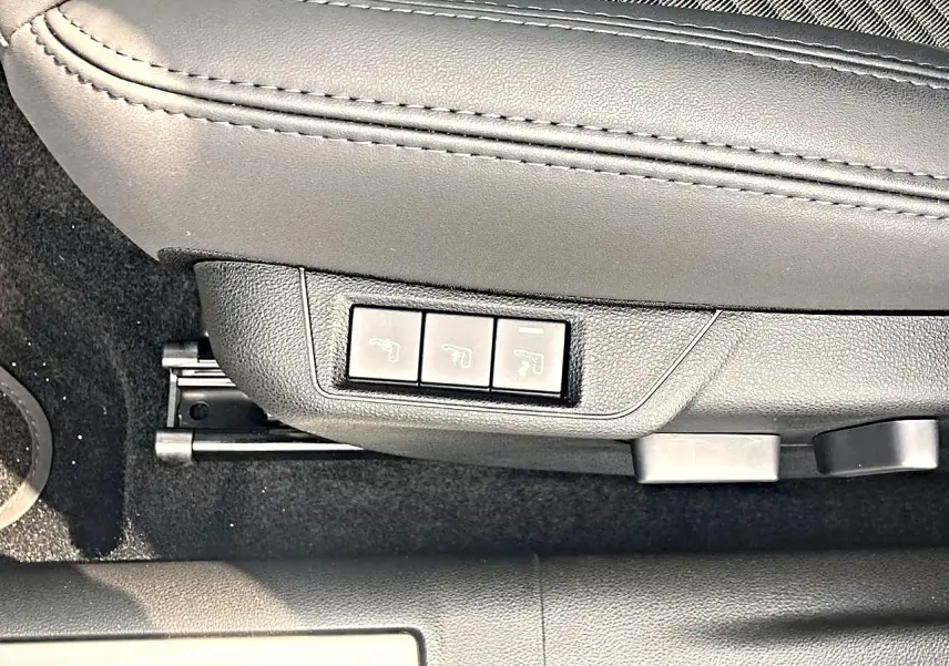 Gros plan sur les commandes électriques du siège conducteur noir de l'Alfa Romeo Junior 1.2 hybride gris 2026.