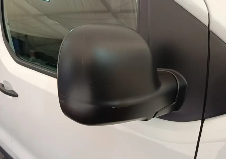 Gros plan sur le rétroviseur noir côté droit du Peugeot Expert Fourgon blanc, vue latérale partielle.
