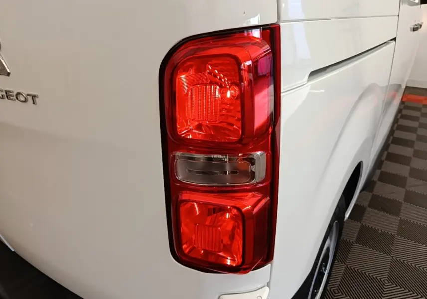Gros plan sur le feu arrière droit d’un Peugeot Expert Fourgon blanc, avec partie latérale visible en intérieur.