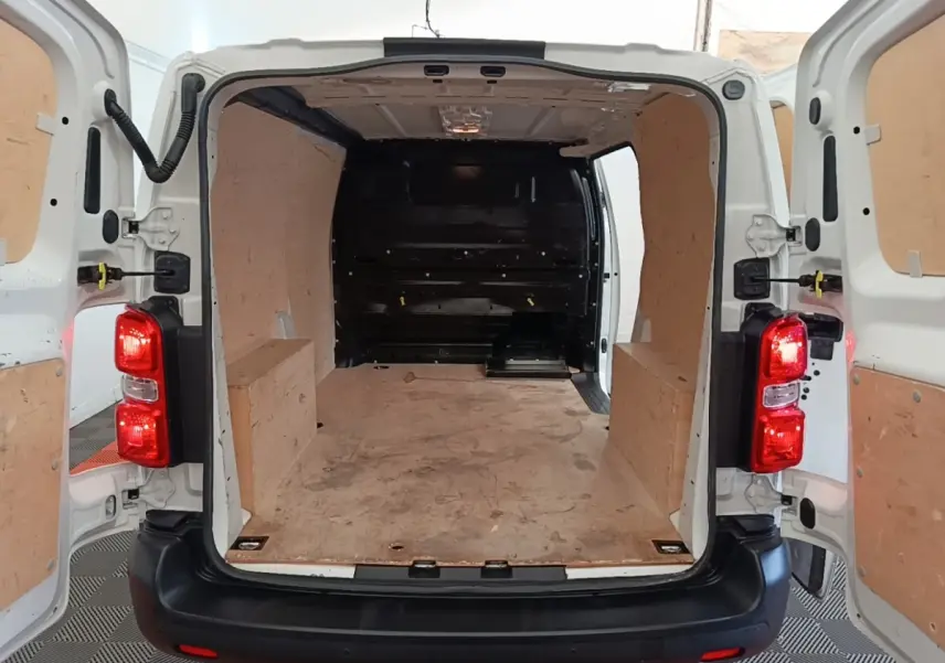 Vue arrière ouverte du Peugeot Expert Fourgon blanc 2020 montrant l'espace de chargement avec cloison pleine en bois.