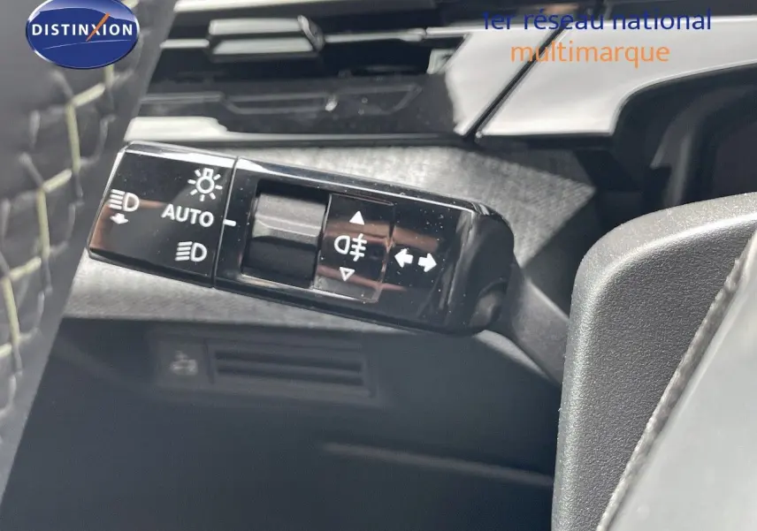 Gros plan sur la commande des feux automatiques et antibrouillard à gauche du volant du Peugeot 5008 noir perle métal 2025.