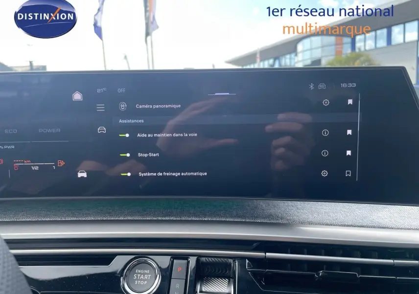 Tableau de bord du Peugeot 5008 Hybrid 2025 avec écran tactile affichant les aides à la conduite, intérieur moderne noir.
