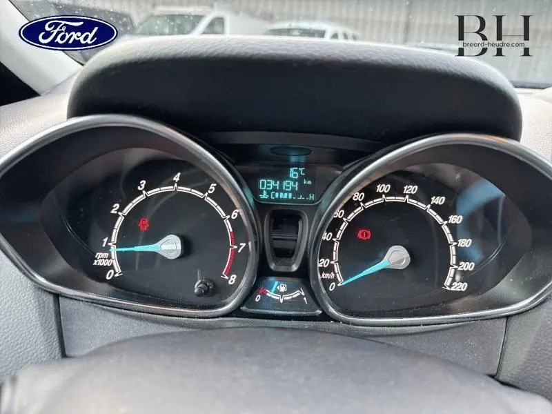 Gros plan sur le tableau de bord noir du Ford B-MAX blanc, affichant compte-tours, vitesse et écran digital.