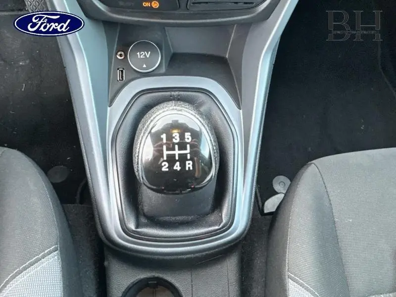 Vue rapprochée du levier de vitesses manuel noir au centre de la console d'une Ford B-MAX blanche Glacier de 2017.