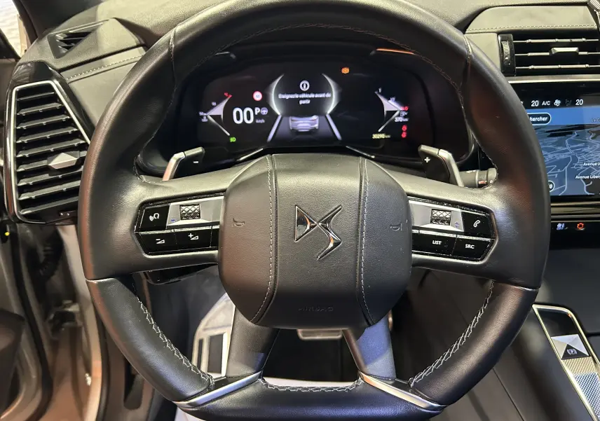 Volant en cuir noir avec logo DS au centre, tableau de bord numérique et écran tactile de navigation du DS7 2024.