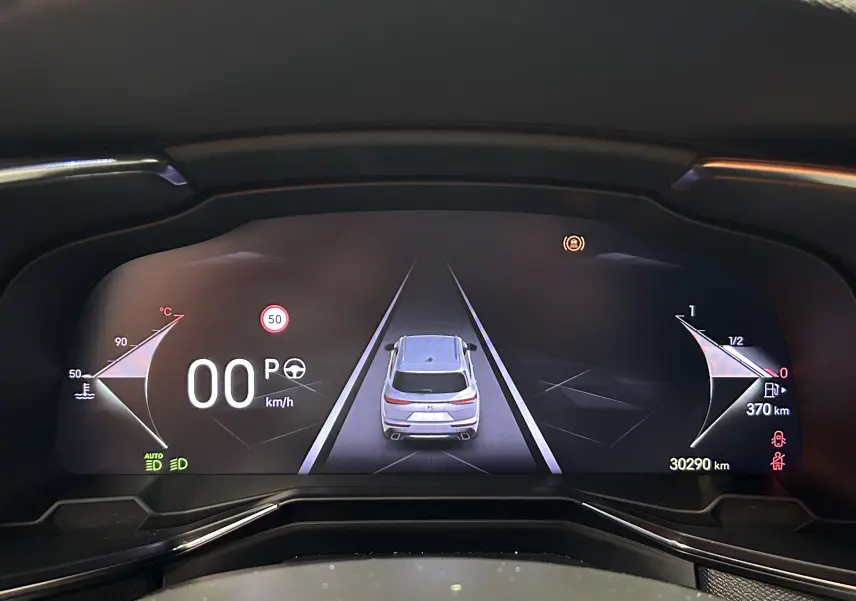 Tableau de bord numérique du DS7 BlueHDI 130, affichant la voiture vue de dessus et les indicateurs de vitesse et carburant.