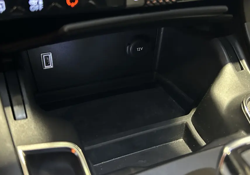 Gros plan sur la console centrale noire du DS7 2024 avec prise USB et prise 12V visibles.