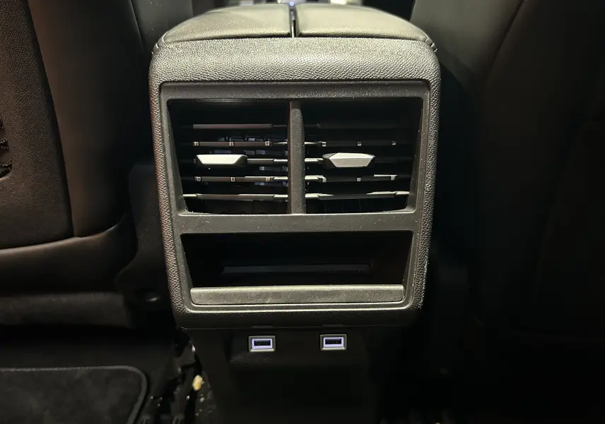 Prise de vue rapprochée des aérateurs arrière et ports USB du DS7 BlueHDI 130 en intérieur noir.