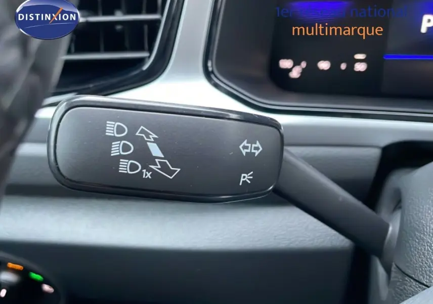 Gros plan sur le commodo gauche du volant du Volkswagen T-Roc noir grenadilla, avec commandes des feux et clignotants.