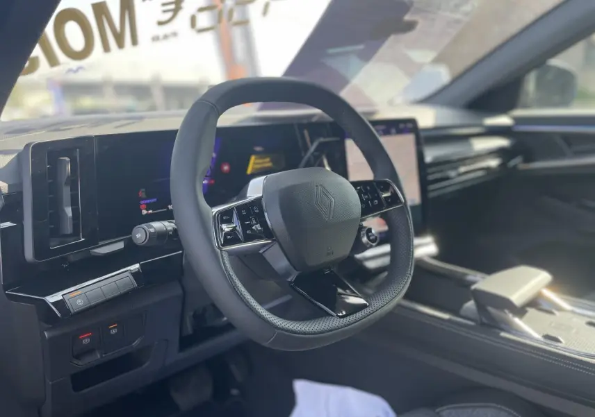 Vue intérieure centrée sur le volant noir de la Renault Rafale 2025 avec tableau de bord numérique et écran tactile.