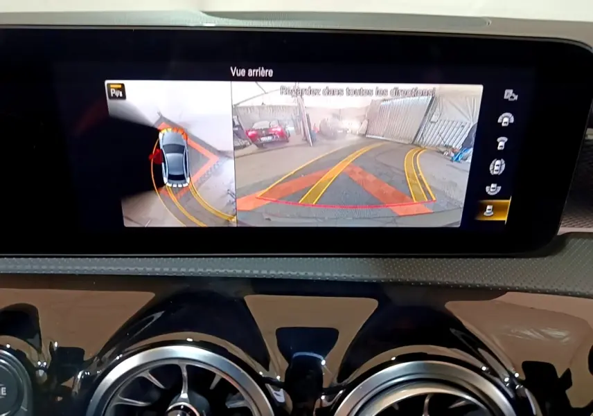 Écran central affichant la caméra de recul et vue 360° dans une Mercedes Classe A noire, tableau de bord moderne.