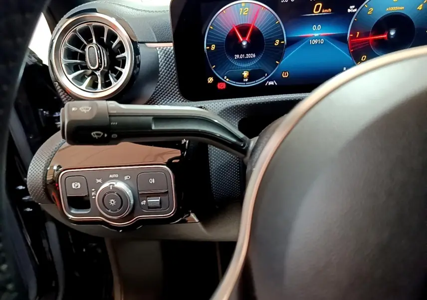 Vue intérieure côté gauche du tableau de bord de la Mercedes Classe A 200 d, avec commandes d’éclairage et écran digital lumineux.