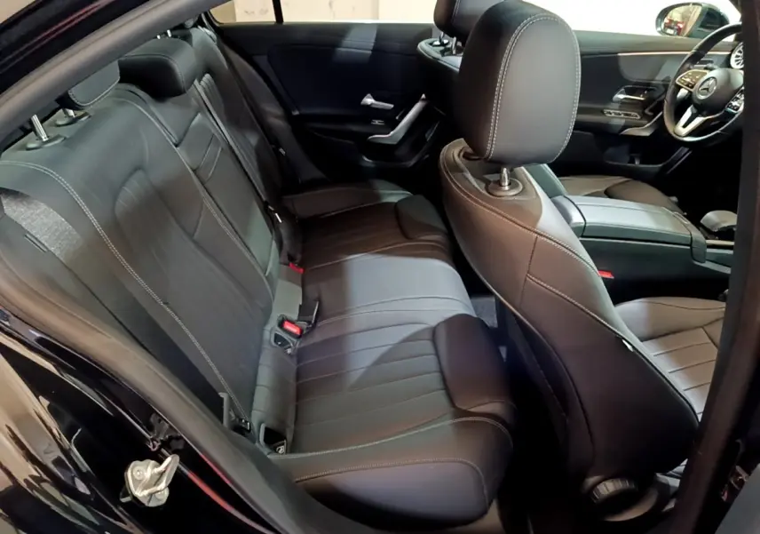 Vue intérieure côté droit de la banquette arrière et sièges avant en cuir noir d'une Mercedes Classe A Berline 2022.