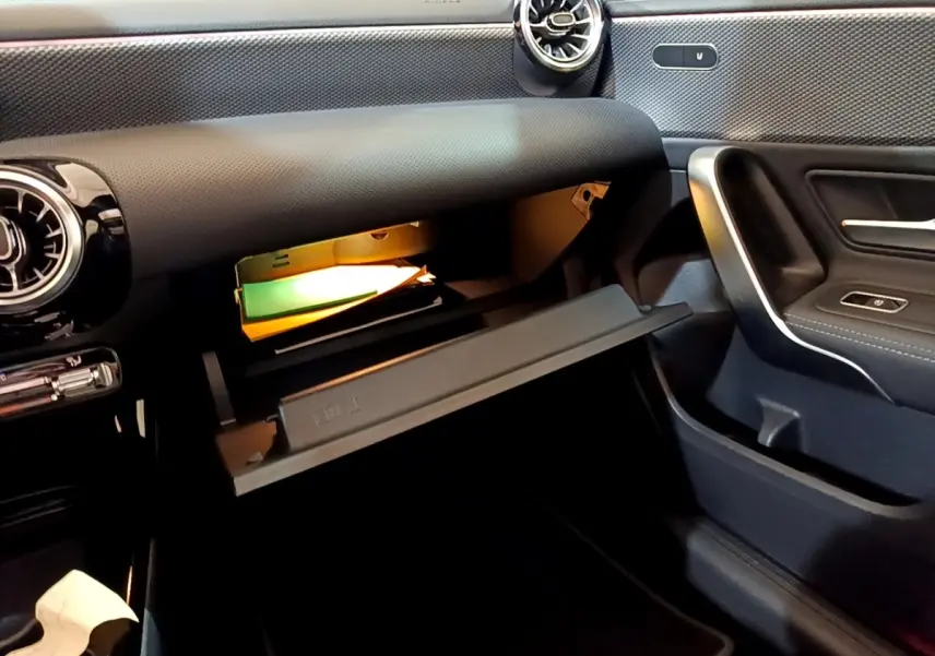Intérieur de la Mercedes Classe A 200 d 2022, vue côté passager sur la boîte à gants ouverte avec éclairage intérieur.
