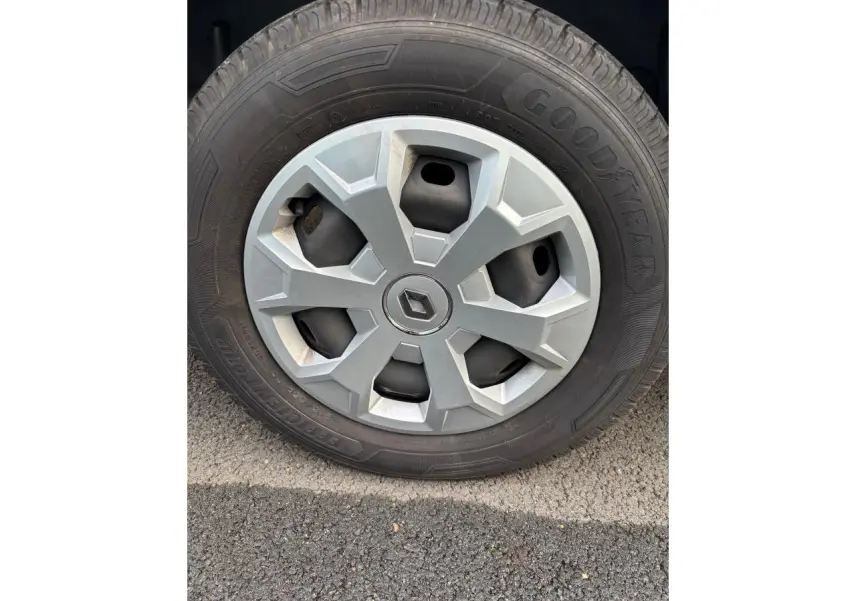 Gros plan sur la roue avant droite du Renault Trafic Fourgon gris clair avec jante en alliage et logo Renault central.