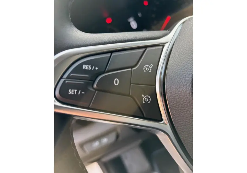 Gros plan sur les commandes du régulateur de vitesse au volant noir du Renault Trafic Fourgon gris clair 2022.