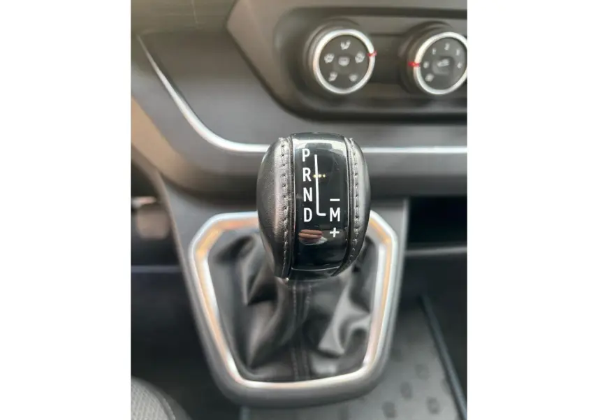 Gros plan sur le levier de vitesses automatique noir du Renault Trafic Fourgon 2022, entouré de garniture argentée.
