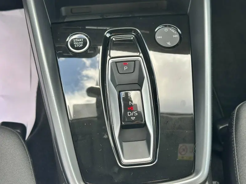 Gros plan sur la console centrale noire brillante avec sélecteur de boîte auto et bouton Start/Stop de l'Audi A3 Sportback.