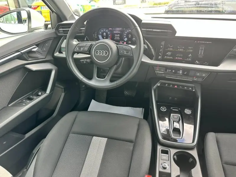Intérieur de l'Audi A3 Sportback 2024, vue du poste de conduite avec volant cuir multifonction et écran digital.