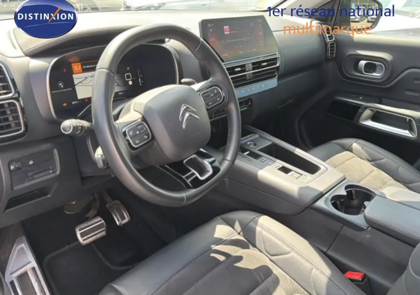 Intérieur du Citroën C5 Aircross 2023 en gris acier, vue côté conducteur montrant volant, tableau de bord et console centrale.
