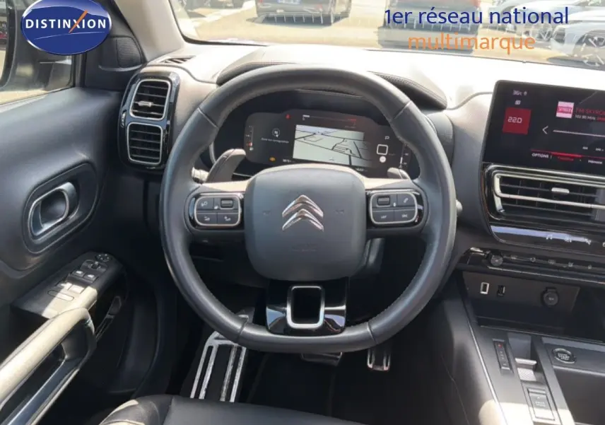 Vue intérieure centrée sur le volant et le tableau de bord du Citroën C5 Aircross 2023, finition noire moderne.