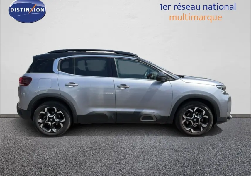 Profil droit d'un Citroën C5 Aircross gris acier 2023 avec toit noir et jantes alliage bicolores.
