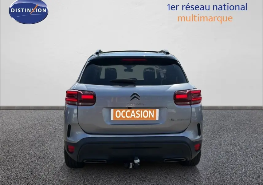 Vue arrière d'un Citroën C5 Aircross gris acier 2023 avec hayon fermé et attelage visible.