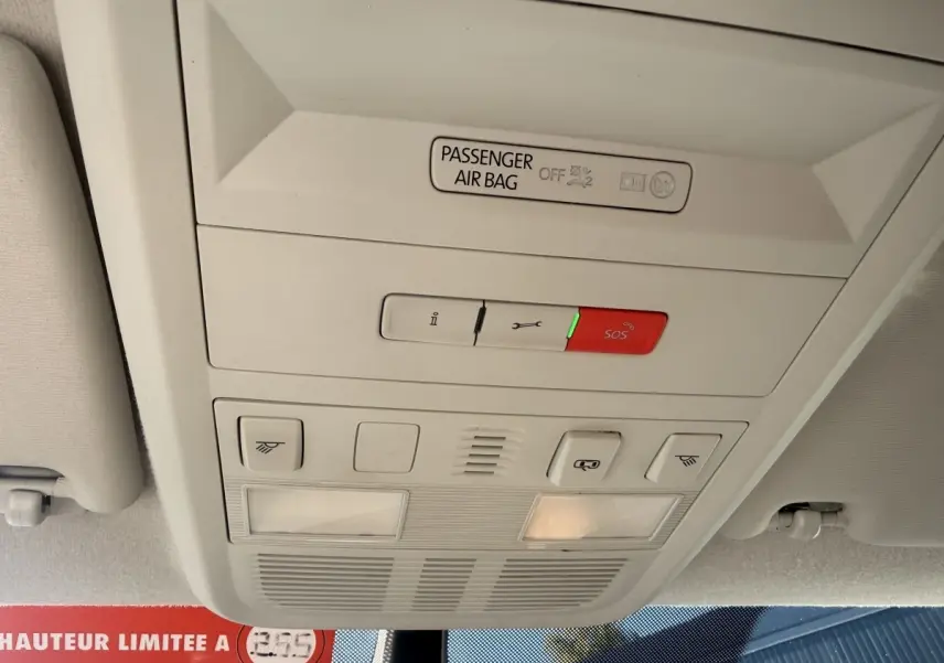 Vue intérieure du plafonnier gris clair du Volkswagen Transporter 2.0 TDi 110 L2H1 Business avec bouton SOS rouge allumé.