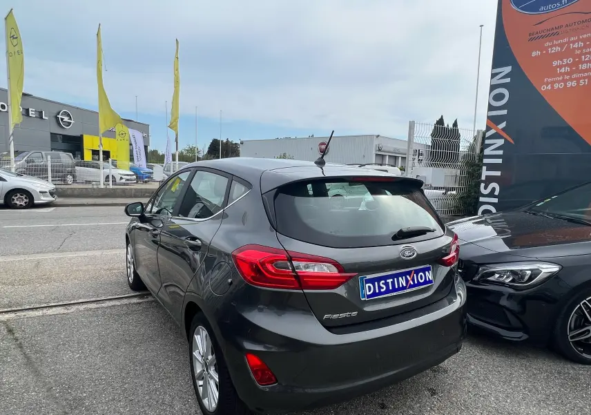 Vue 3/4 arrière droite d'une Ford Fiesta gris foncé 2018 avec feux arrière distinctifs et antenne de toit.
