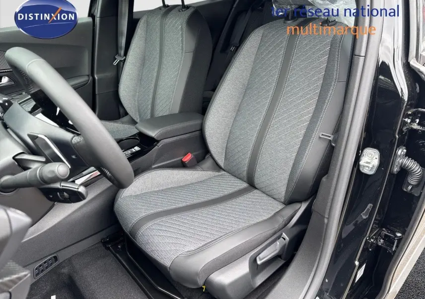 Vue intérieure côté conducteur du Peugeot 2008 Hybrid 136ch Allure noir métal, sièges tissu et cuir noir avec motifs gris.
