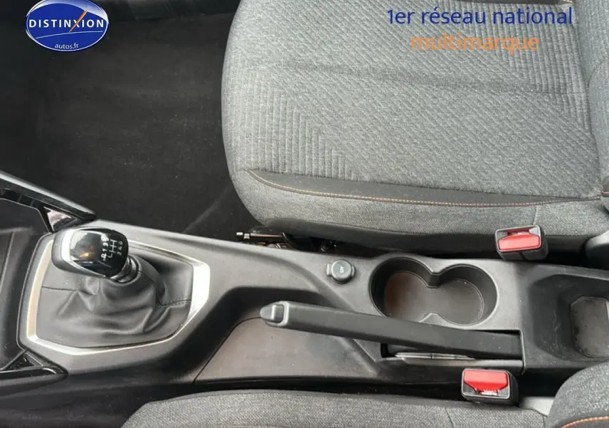 Vue rapprochée de la console centrale de la Peugeot 208 noire, montrant levier de vitesse manuel et frein à main.