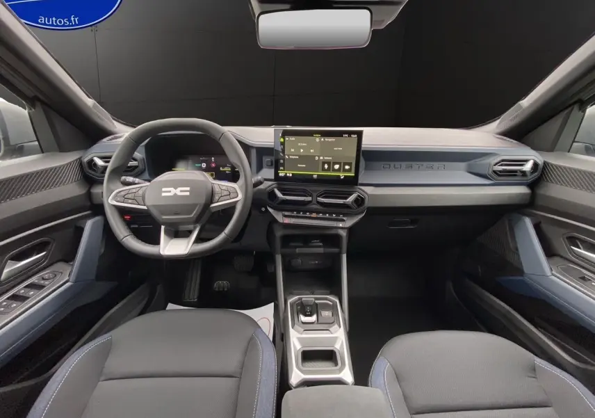 Vue intérieure avant du Dacia Duster Full Hybrid 140 gris schiste, avec tableau de bord moderne et écran central tactile.