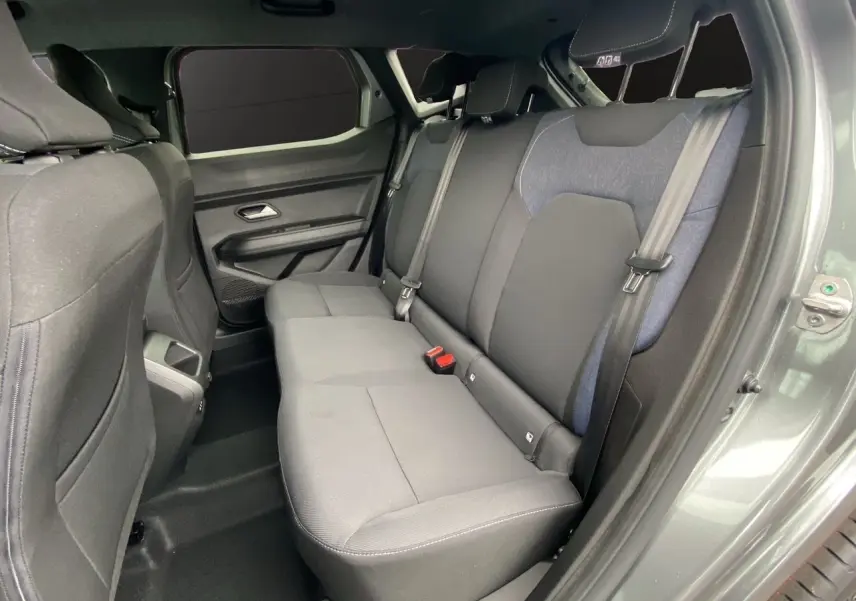 Vue intérieure côté droit des sièges arrière du Dacia Duster 2025 gris schiste, montrant les ceintures et les finitions tissu bicolore.