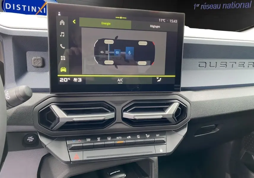 Vue intérieure du tableau de bord du Dacia Duster 2025 gris schiste, avec écran tactile et aérateurs hexagonaux.