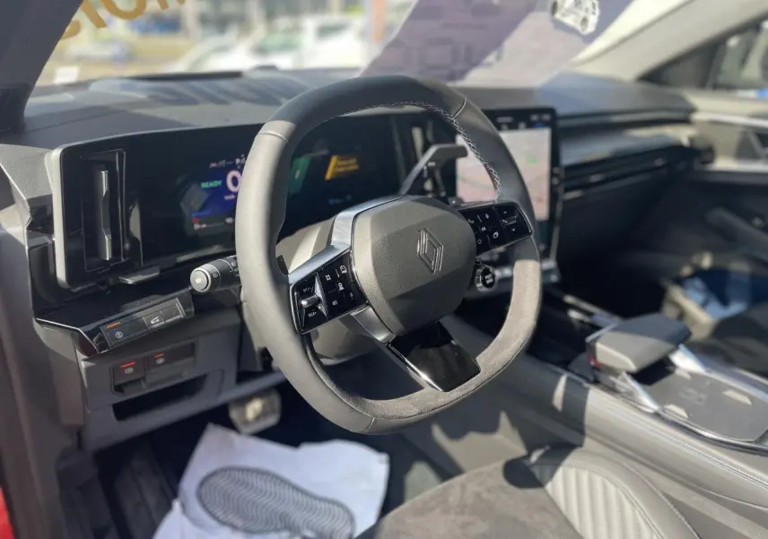 Intérieur Renault Rafale 2025 vu côté conducteur, volant Alcantara, planche de bord noire et écran tactile vertical.