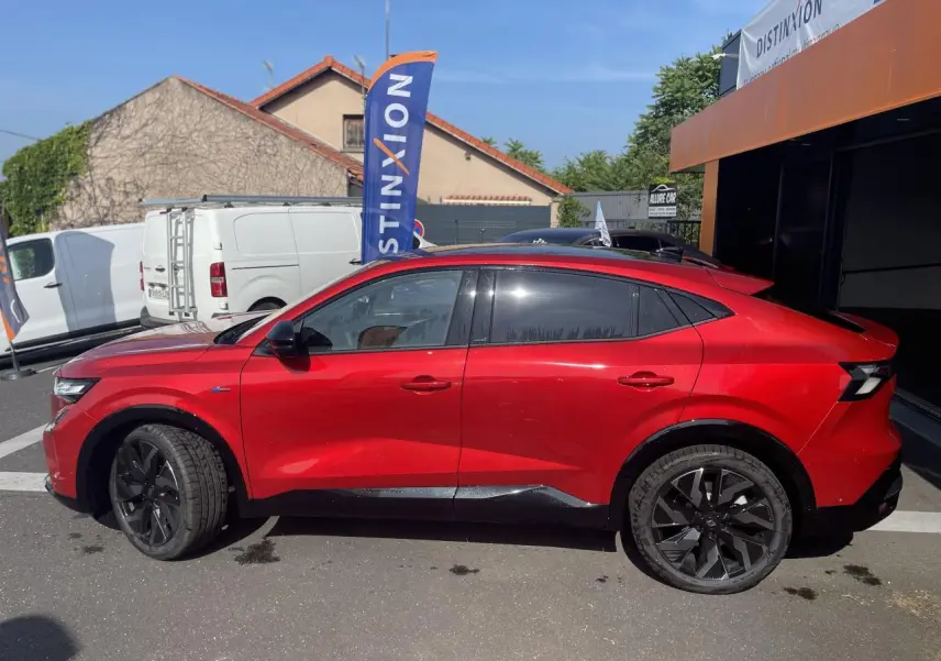 Profil droit de la Renault Rafale rouge avec toit noir, jantes noires et lignes dynamiques visibles en extérieur.