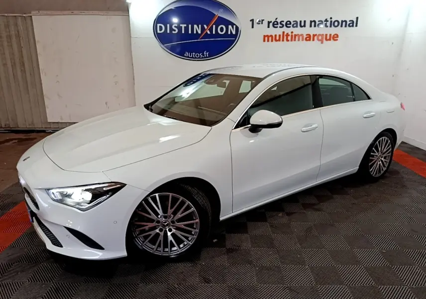 Mercedes Classe CLA 200 d Business Line blanc vue 3/4 avant droit, phares allumés et jantes alliage multibranches.