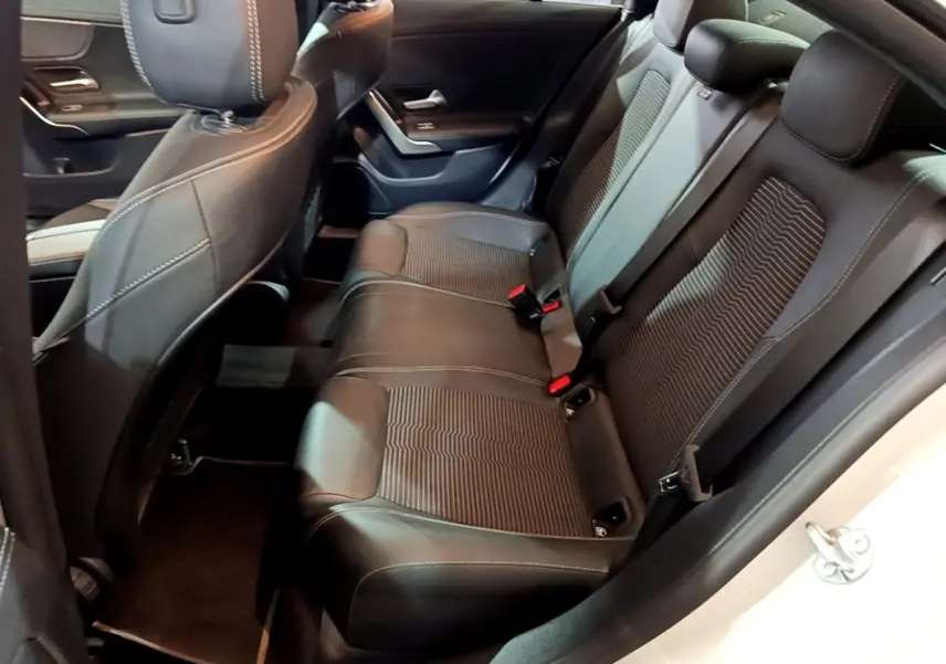 Vue intérieure côté droit des sièges arrière noirs en cuir et tissu d'une Mercedes CLA 200 d Business Line blanche.