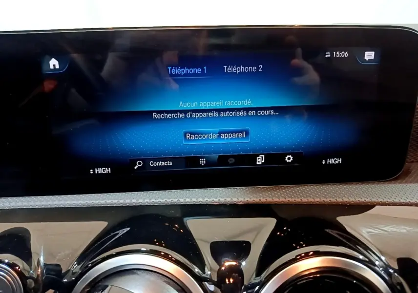 Vue rapprochée de l’écran tactile central bleu et des aérateurs ronds noirs du tableau de bord de la Mercedes CLA 200 d Business Line blanche.
