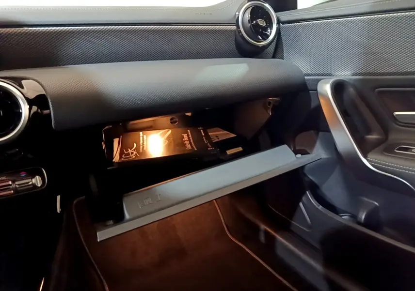 Intérieur de la Mercedes CLA 200 d Business Line 2021, vue côté passager sur boîte à gants ouverte avec manuel visible.