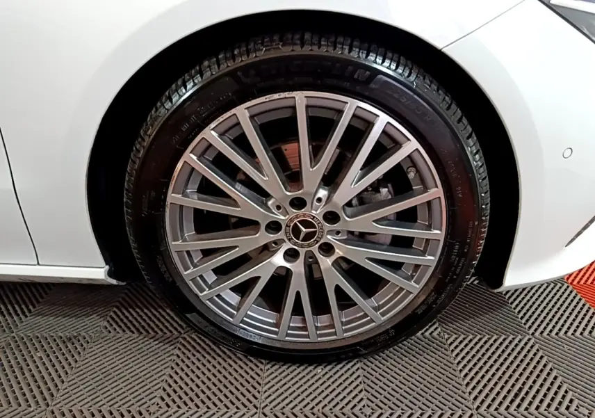 Gros plan sur la roue avant droite argentée d’une Mercedes CLA 200 d Business Line blanche, avec jante multi-branches.