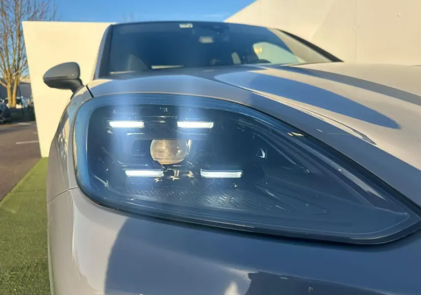 Gros plan sur le phare avant gauche du Porsche Cayenne 2024 gris arctique, mettant en valeur son design LED distinctif.