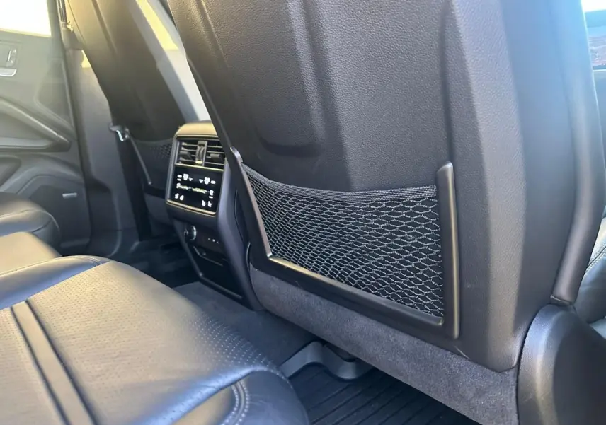 Vue intérieure arrière du Porsche Cayenne 2024, montrant les sièges en cuir noir et la console centrale avec commandes climatisation.