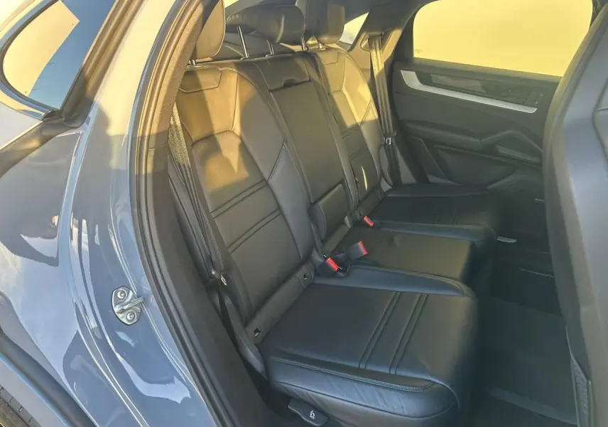 Vue intérieure côté gauche des sièges arrière en cuir noir du Porsche Cayenne III Coupe 2024 gris arctique.