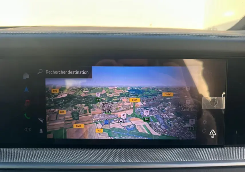 Écran tactile du système de navigation du Porsche Cayenne 2024, affichant une carte en vue satellite.